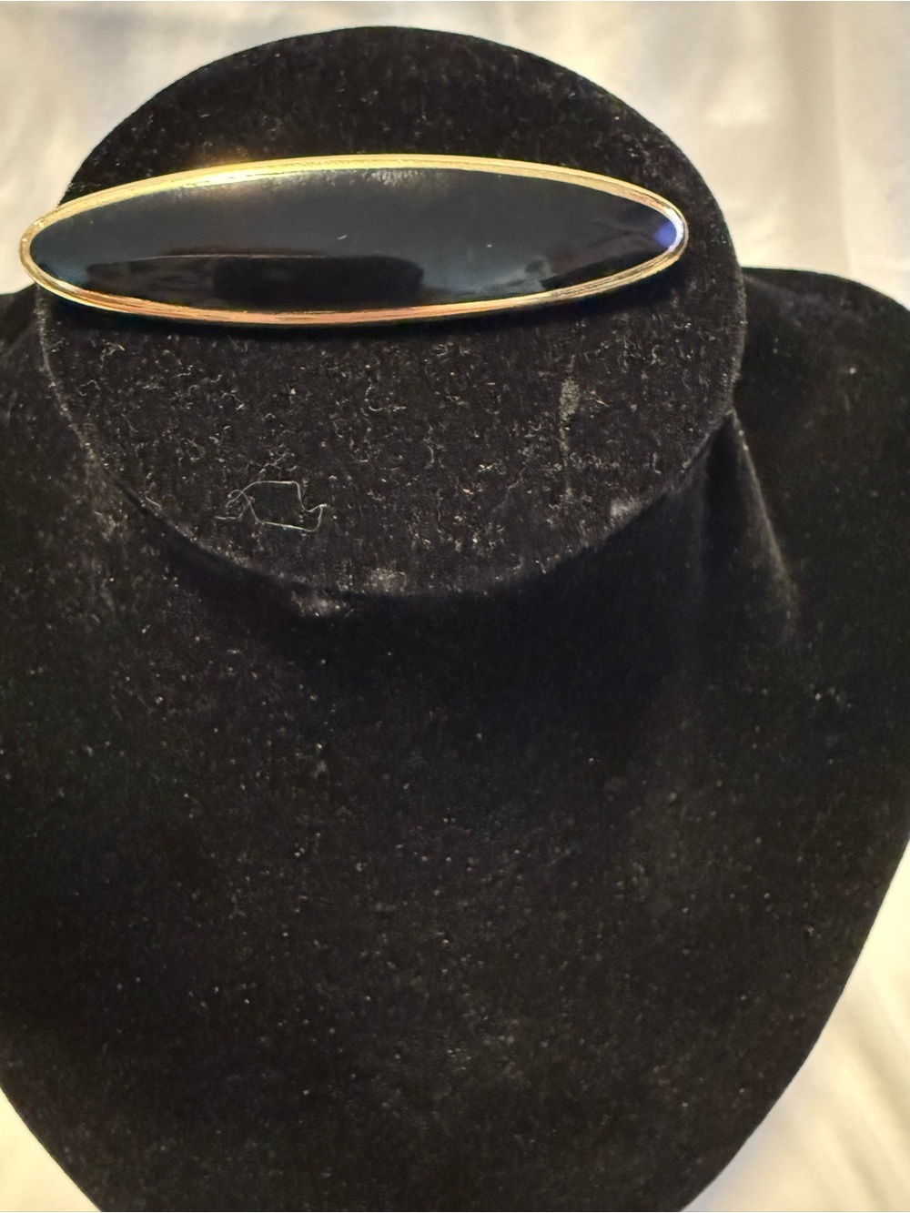 vintage Monet brooch w/sleek, black enamel center framed in polished gold tone